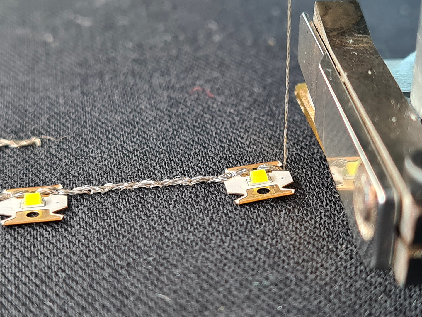 ZSK LED sequins V3.1 placed with the ZSK Functional Sequin Device and connected with conductive thread.