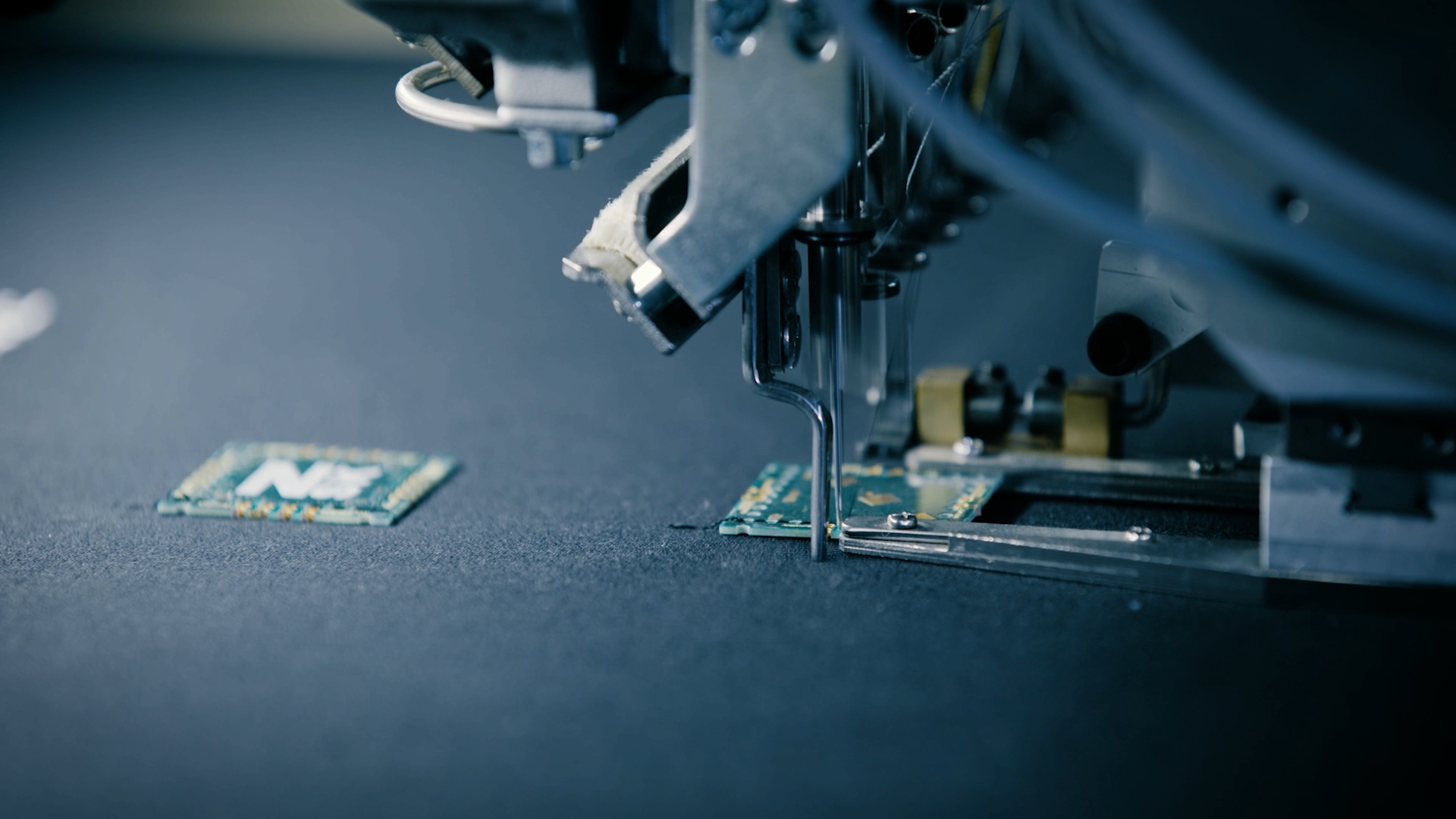 Close-up of ZSK PCB Placement Device placing PCBs on fabric